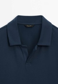 Polo bleu marine avec un col classique et une ouverture subtile en V, fabriqué en tissu texturé.