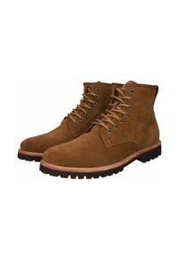Botas de ante marrón con cordones, puntera redondeada, suela de goma y detalles de costura en contraste. Ojetes metálicos y tobillo de altura media.