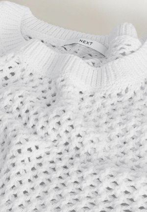 Hvid strikket sweater med ribkant ved halsen og en inderlabel, der viser mærkenavnet "NEXT."