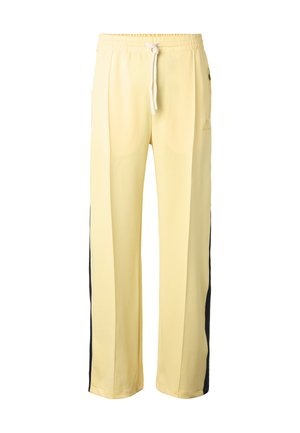 Pantaloni sportivi giallo chiaro con vita elastica, coulisse bianca e strisce laterali scure, vestibilità a gamba dritta.