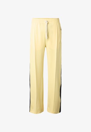 Pantaloni sportivi giallo chiaro con vita elastica, coulisse bianca e strisce laterali scure, vestibilità a gamba dritta.