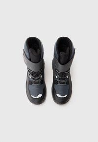 Sorte og grå sneboots med en tekstureret overflade, kontrasterende accenter, justerbar spænde og snørebånd til lukning, med et højt design.