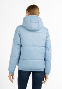 Lichtblauwe pufferjack met capuchon, met een gewatteerd ontwerp, elastische manchetten en zoom, gemaakt van glad, waterafstotend materiaal.