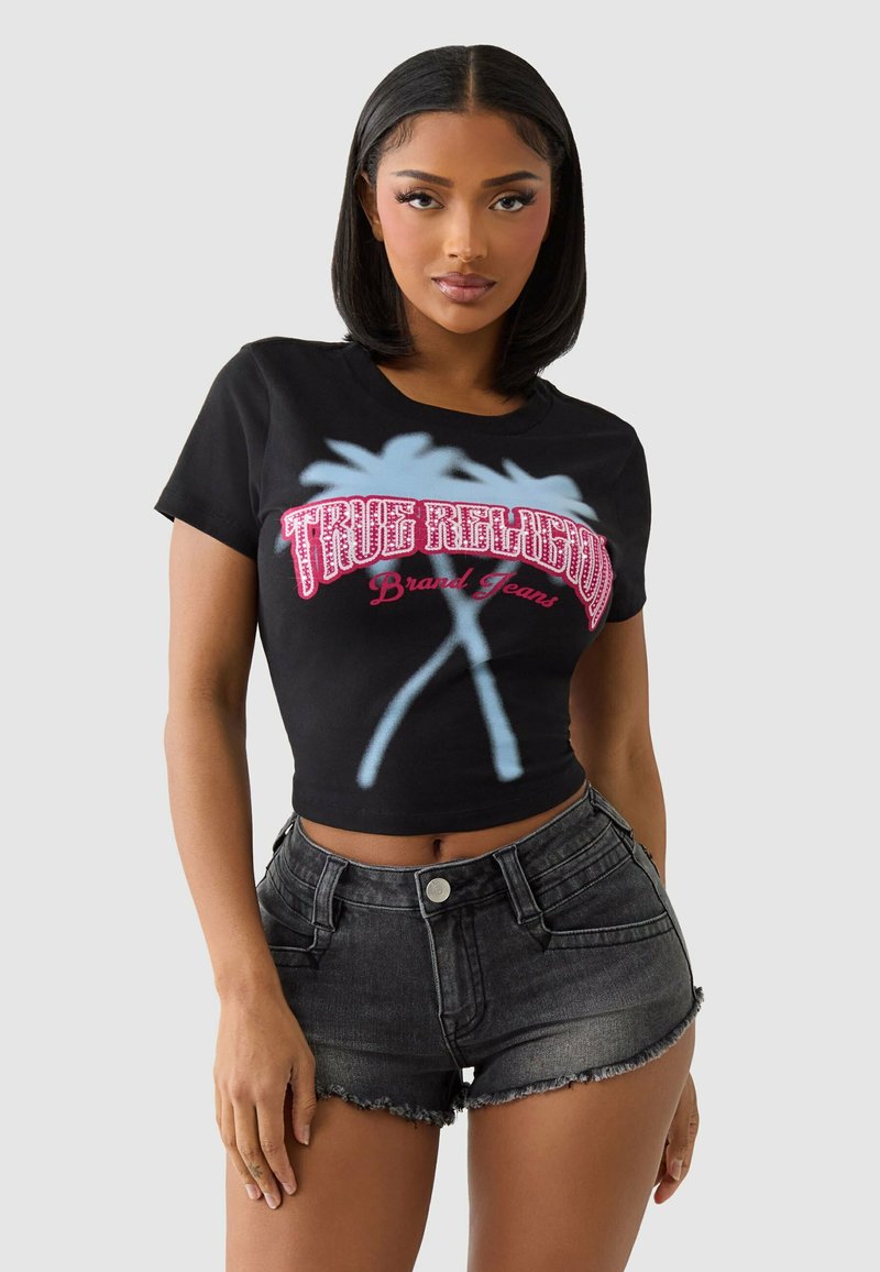 Black cropped t-shirt featuring a graphic design in pink and blue with "True Religion Brand Jeans" text, paired with high-waisted black denim shorts.