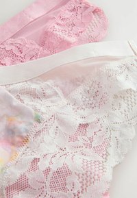 Paar Damenunterwäsche bestehend aus einer Kombination aus transparentem rosa und weißem Spitzenstoff mit Blumenmustern, weichen elastischen Taillenbändern und farbenfrohen Akzenten.