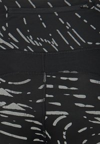 Czarne legginsy z szarym abstrakcyjnym wzorem. Posiadają elastyczny pas i gładki, rozciągliwy materiał z wzmocnionymi szwami.