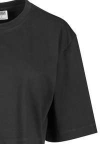 Černé zkrácené tričko z bavlny s kulatým výstřihem a krátkými rukávy. Má hladkou texturu a minimální detaily šití.