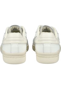 Baskets en cuir blanc avec une semelle beige texturée, présentant un design lisse et épuré ainsi que des détails de couture subtils sur le talon.
