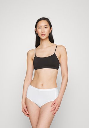 Svart lett cami med tynne stropper, kombinert med hvite høyhårede truser; begge plagg har en glatt tekstur og et minimalistisk design.