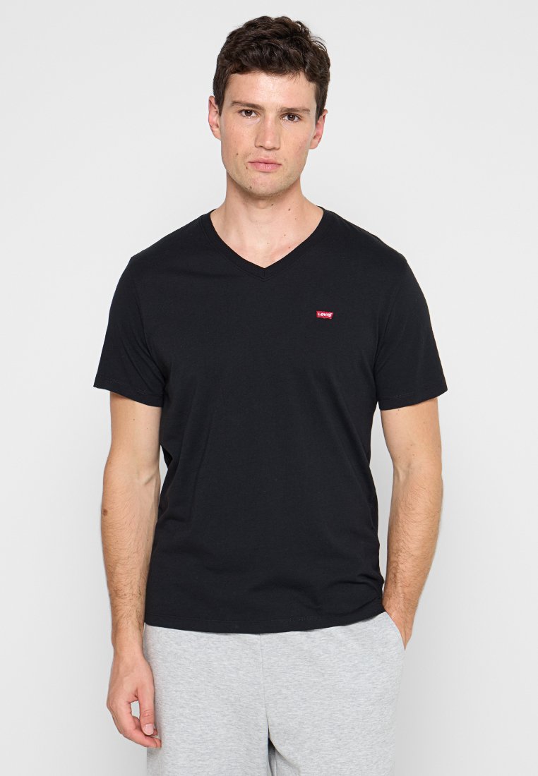 Czarny krótki rękaw T-shirt z dekoltem w serek wykonany z bawełny, z małym czerwonym logo Levi's na piersi, w połączeniu z szarymi spodniami dresowymi.