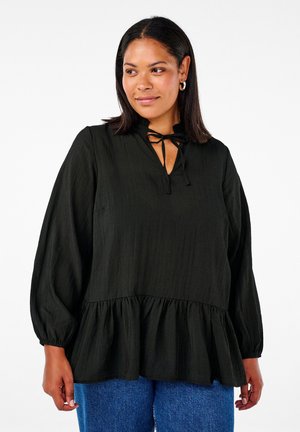 Black, textured blouse with a ruffled hem, keyhole neck with ribbon tie, long sleeves, and loose fit. Paired with blue denim jeans.