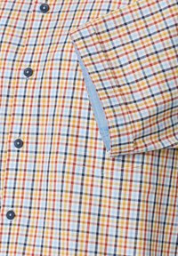 Kurzarm-Hemd mit kariertem Muster in Blau, Orange, Gelb und Weiß, dunklen Knöpfen und einem kontrastierenden hellblauen Innenfutter.