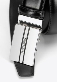 Schwarzer Ledergürtel mit einer silbernen rechteckigen Schnalle mit strukturierter Oberfläche und eingraviertem "WITTCHEN"-Logo, welches ein modernes Design unterstreicht.