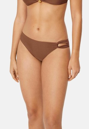 Parte inferior de bikini marrón con detalle de corte lateral, usada por una persona de pie, mostrada desde el abdomen hasta los muslos sobre un fondo liso.