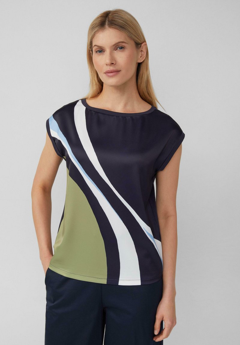 Kurzarm-Bluse mit einem mehrfarbigen Wirbelmuster in Marineblau, Grün, Weiß und Hellblau auf glattem Stoff.