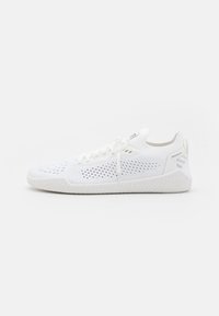 Hvit sportsko med mesh-overdel og ventilasjonsåpninger, flate lisser og en teksturert gummisåle med et mønstret design.