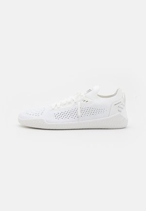White athletic shoes featuring a mesh upper with ventilation holes, flat laces, and a textured rubber sole with a patterned design.