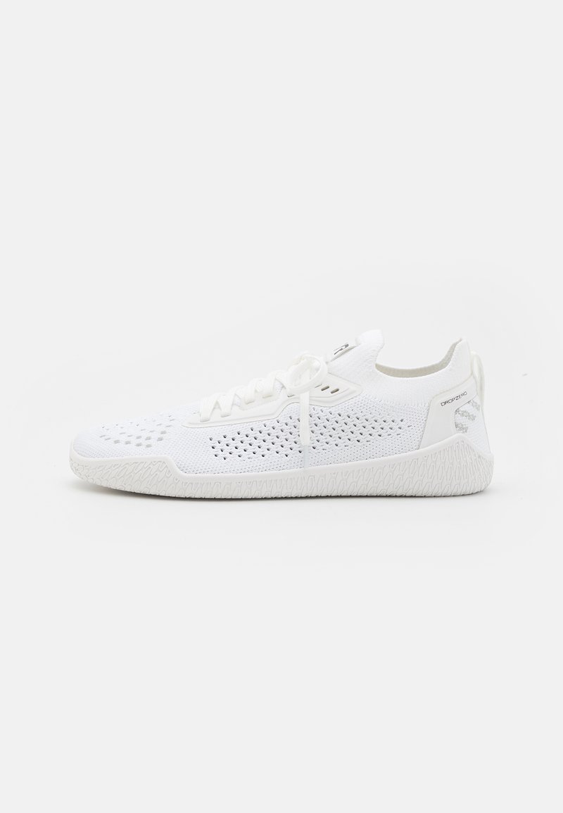 Hvit sportsko med mesh-overdel og ventilasjonsåpninger, flate lisser og en teksturert gummisåle med et mønstret design.