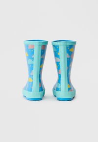 Bottes de pluie bleues avec une finition brillante, arborant un motif de nuage et de gouttes de pluie. La semelle et les accents supérieurs sont en bleu clair, avec une prise texturée.