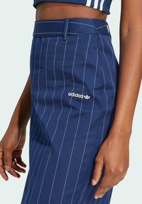 Marineblå randig kjol med vit söm, med Adidas-logotyp. Skräddarsydd design med åtsittande midja och slät yta.