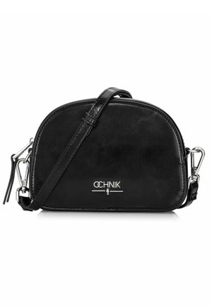 Czarna skórzana torebka crossbody o zaokrąglonym kształcie, z srebrnymi detalami i paskiem na ramię. Posiada logo z przodu oraz eleganckie wykończenie.