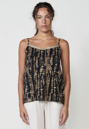 Zwarte top met een gouden abstract patroon, met dunne bandjes en een decoratieve metallic rand langs de halslijn. Zachte stoftextuur.
