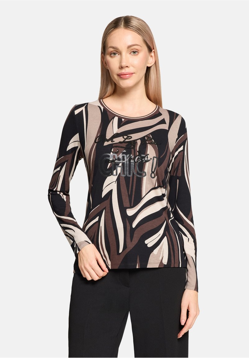 Długie rękawy w brązowy, czarny i beżowy wzór liści. Posiada okrągły dekolt oraz graficzny nadruk "Chic!" z cekinami. Gładka struktura.