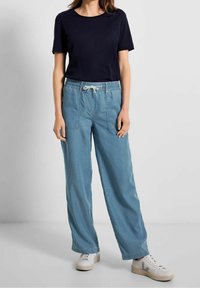 Top de manga corta navy combinado con pantalones sueltos de cintura elástica de color azul claro, que cuentan con dos bolsillos laterales y un cordón.