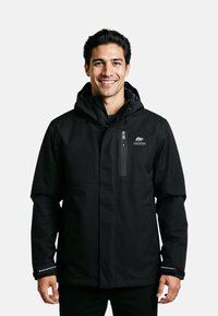 Zwarte waterdichte jas met een ritszak op de borst, een verstelbare capuchon en reflecterende accenten op de manchetten. Glad stofoppervlak.