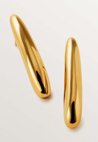 Pendientes de metal dorado con un diseño liso y alargado. Cuentan con un acabado brillante y extremos afilados, destacando su forma estilizada.
