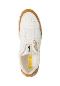 Adidaș alb cu detalii maro, vârful perforat, șireturi albe, etichetă "MoEa" pe limbă și text galben "Corn." în interiorul zonei călcâiului.