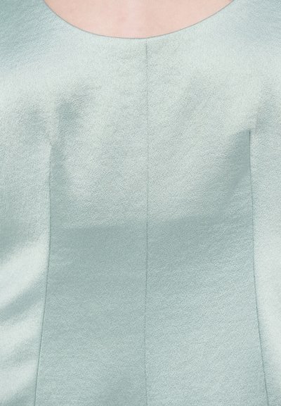 Top senza maniche azzurro chiaro realizzato in tessuto testurizzato, con scollatura rotonda e design strutturato con dettagli sui pannelli. 