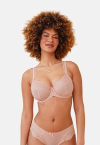 Bra and panty set in soft nude fabric, featuring lace trim, polka dot texture, and intricate geometric patterns, with a central bow accent.