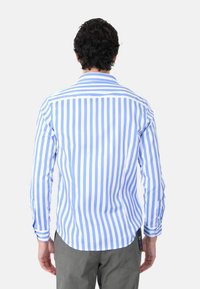 Camicia a maniche lunghe a righe blu e bianche con polsini abbottonati, colletto classico e orlo curvo. Presenta un'etichetta sul lato inferiore sinistro.