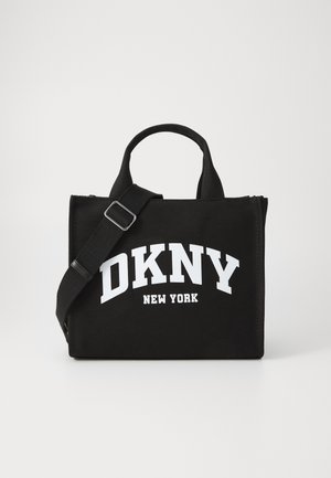 Juodas drobės rankinys su užtrauktuku, su baltu „DKNY NEW YORK“ logotipu ryškiu šriftu, trumpomis rankenomis ir reguliuojamu peties diržu.