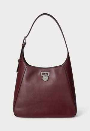 Burgunderfarbenes Lederhandtasche mit runder Form, verstellbarem Riemen und silbernen Beschlägen, mit einem Verschlussdetail an der Vorderseite.