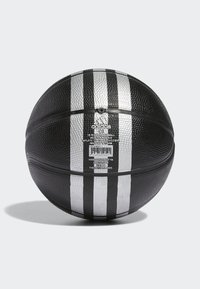 Balón de baloncesto de goma con una superficie texturizada, diseño de franjas negras y plateadas, y una etiqueta impresa con los detalles del producto en un lado.