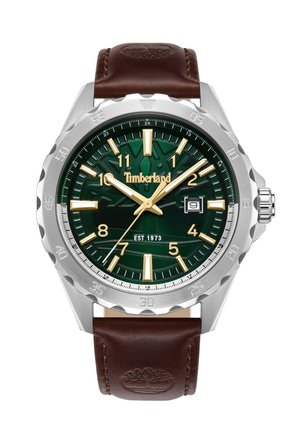 Montre Timberland avec un boîtier en acier inoxydable, un cadran texturé vert, des index dorés et un bracelet en cuir marron portant un logo.