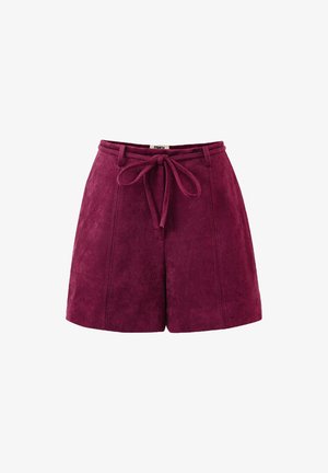 Hochtaillierte pflaumenfarbene Wildleder-Shorts mit Vordernähten, Gürtelschlaufen und einem gebundenen Stoffgürtel in der Taille auf weißem Hintergrund.