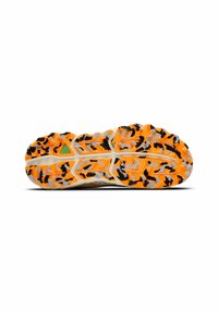 Trailrunning-Schuhsohle mit einem mehrfarbigen Muster in Orange, Schwarz und Grau, das tiefe Stollen für besseren Halt bietet. Grünes Logo-Detail vorhanden.