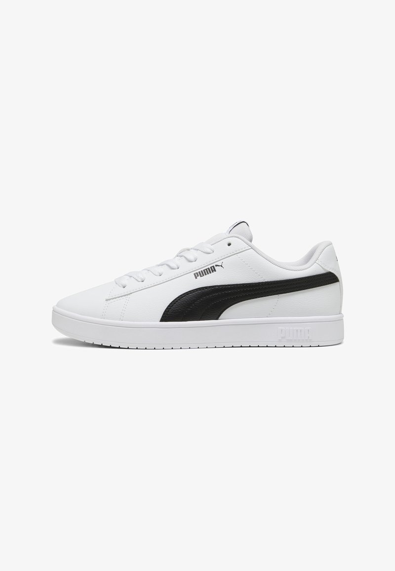 Baskets basses blanches Puma avec bande latérale noire, lacets blancs et logo Puma sur la semelle et le côté, vues de profil.