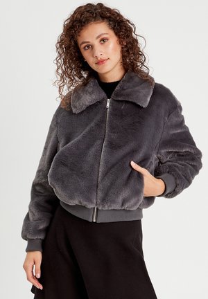 Giacca bomber in pelliccia sintetica grigia con colletto, chiusura frontale a zip e polsini a coste. Presenta una texture morbida e un fit rilassato con tasche laterali.