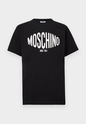 T-shirt in cotone nero con un grande logo bianco "MOSCHINO" e la scritta "SINCE 1983", con scollo classico a girocollo e maniche corte.
