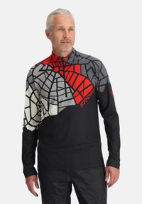 Zwarte langärmlige top met een geometrisch rood en grijs patroon. Beschikt over een ritssluiting bij de hals en een gestructureerde stof, ideaal voor activiteiten buiten.