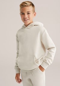 Felpa con cappuccio di un beige chiaro, realizzata in morbido tessuto, con tasca a marsupio e polsini a costine, abbinata a pantaloni jogger coordinati.