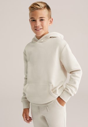 Felpa con cappuccio di un beige chiaro, realizzata in morbido tessuto, con tasca a marsupio e polsini a costine, abbinata a pantaloni jogger coordinati.