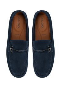 Mørkeblå ruskinds loafers med rund tå, læder indersål og dekorativ metalaccent. Glat tekstur med kontrasterende syninger.