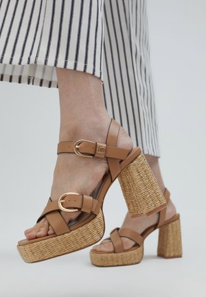 Bruine strappy hoge hakken sandalen met een geweven plateau en blokhak. Bevat een gespsluiting en gladde leren banden.