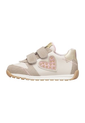 Scarpe da ginnastica beige e bianche per bambini con due bande in velcro e un cuore rosa decorato con borchie dorate sul lato.