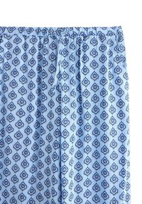 Tessuto blu con motivo a diamante in navy e bianco, dotato di elastico arricciato in cima per un facile appeso.